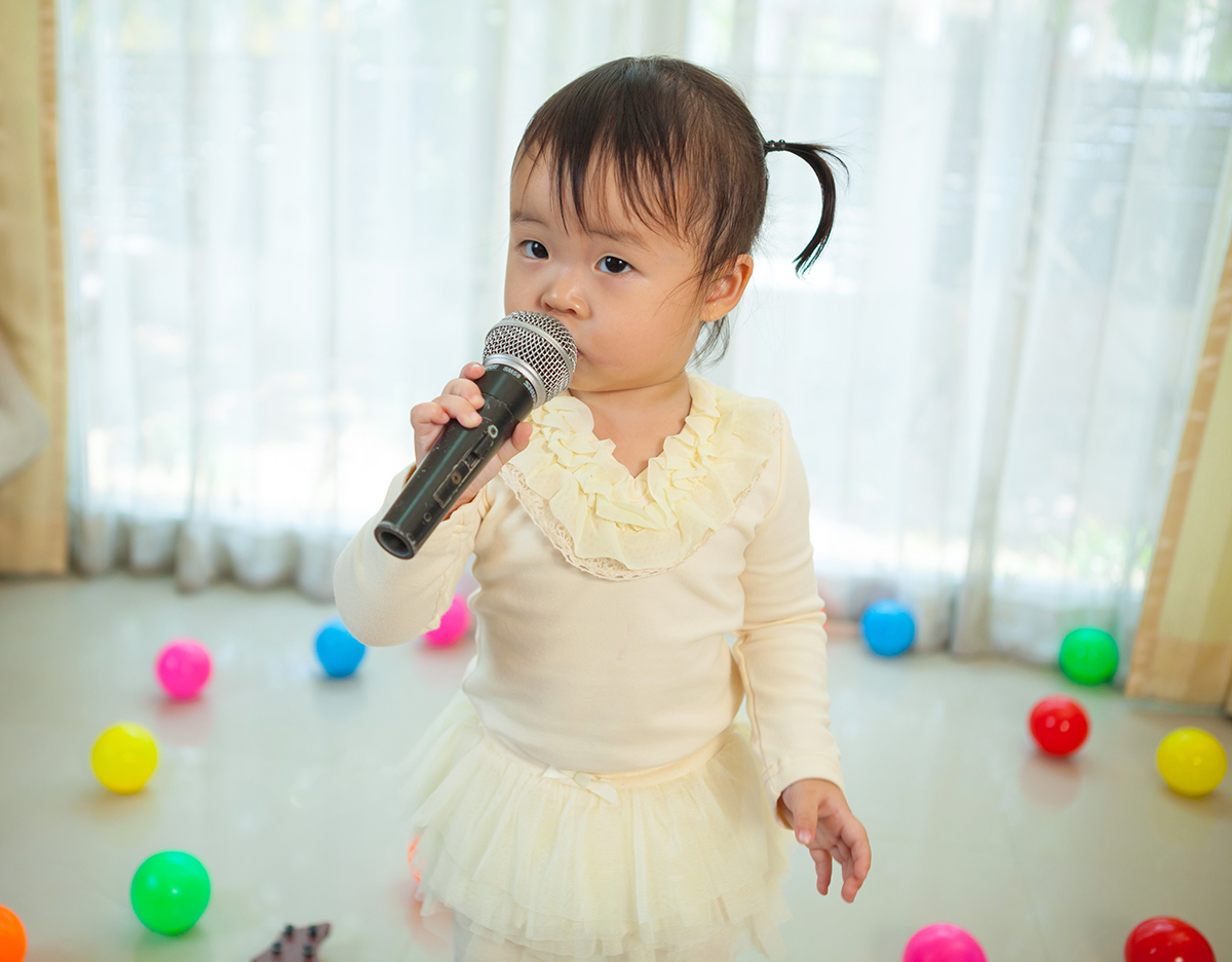 child singing in microphone