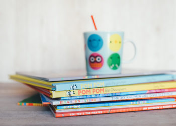 stack of books with child's cup on top