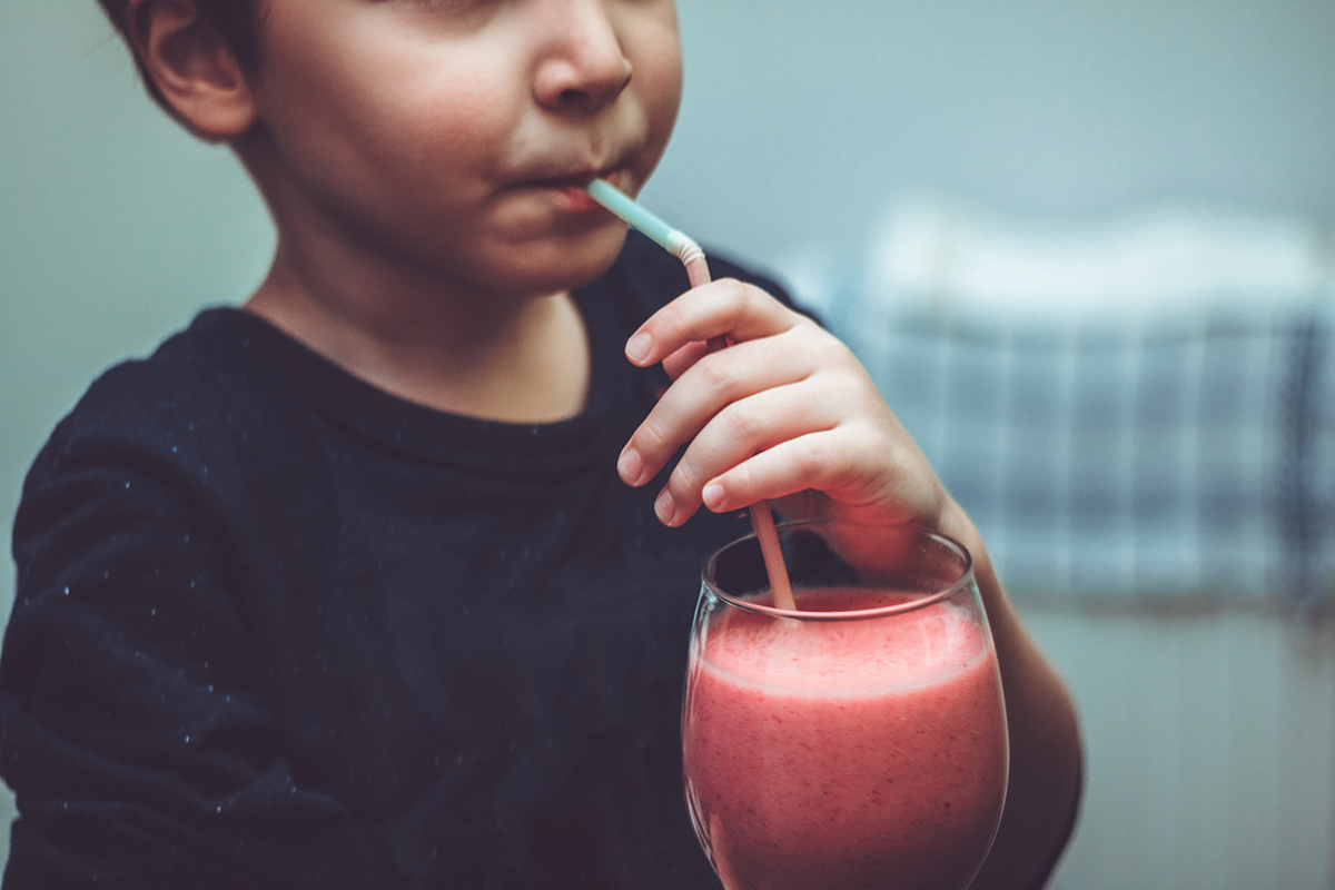 child drinking a smoothie